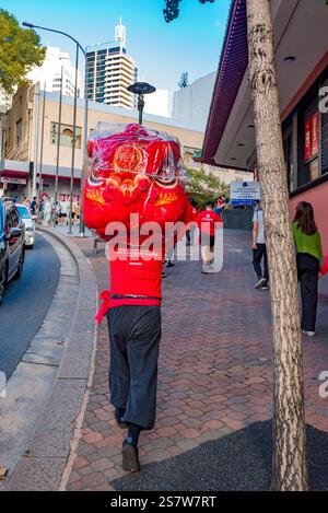 Chinesische Löwentänzer gehen mit einem zerlegten chinesischen Löwen nach einer Aufführung in China Town (Dixon Street) in Sydney, Australien Stockfoto