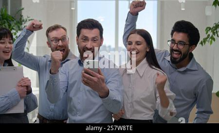 Professionelles Business-Team erfolgreiche multirassische Geschäftsfrauen Geschäftsmänner glückliche Gruppe Kollegen mit Mobiltelefon freuen feiern online erreichen Stockfoto
