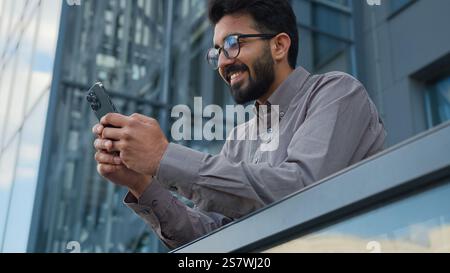 Indischer arabischer Mann männlicher Unternehmer Arbeiter intelligenter Geschäftsmann Büromanager halten Mobiltelefon im Freien Online-Chats schaffen Einblicke in Geschäftsideen Stockfoto