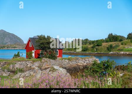 Blick auf die Landschaft der Skotnesosen Bucht mit traditionellem rotem Fischerhaus, genannt rorbu, Ballstad, Lofoten, Norwegen, Europa Stockfoto