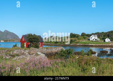 Blick auf die Landschaft der Skotnesosen Bucht mit traditionellem rotem Fischerhaus, genannt rorbu, Ballstad, Lofoten, Norwegen, Europa Stockfoto