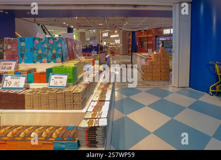 Shenzhen, China - 20. Januar 2025 : Ein Blick auf einen hell beleuchteten Gang in einem russischen Supermarkt. Reihen von bunten verpackten Waren, möglicherweise Schokolade Stockfoto