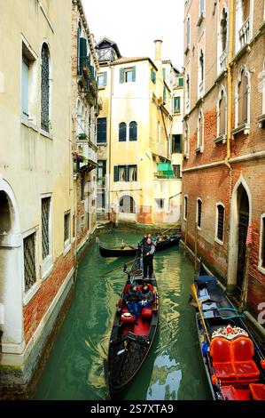 VENEDIG, ITALIEN - 14. FEBRUAR 2015: Viel Gondelverkehr an engen Kanälen am Valentinstag während des Karnevals. Stockfoto