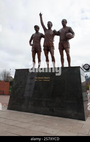 Die Statue der Heiligen Dreifaltigkeit der größten Legenden von Manchester United, Charlton, Law und Best außerhalb des Old Trafford Grounds Stockfoto