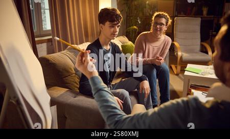 Zweiköpfige Familie, einschließlich Mutter und Sohn im Teenageralter, die Psychologin besucht, diskutiert aktuelle Probleme der Kommunikation zwischen Kind und Eltern Stockfoto