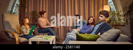 Vierköpfige Familie, einschließlich Eltern, Teenager- und Schulmädchen, die Psychologin besuchen, in einem warmen Raum sitzen, Probleme diskutieren und finden Stockfoto