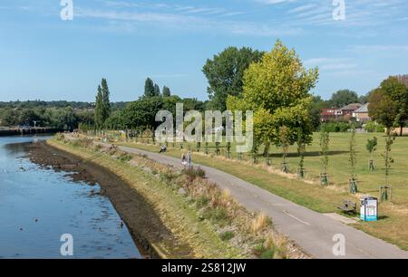 Besucher genießen einen gemütlichen Spaziergang am Ufer des Itchen im Riverside Park in Southampton, England, Großbritannien Stockfoto