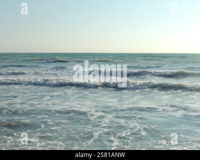 Das Meer ​​ebb ist vom Strand aus sichtbar, Wellenrückschlag ins Meer, schöne Meeresoberfläche an einem sonnigen Tag, Foto der Küste mit Ebbe-Wasser Stockfoto