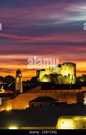 Dubrovnik, Kroatien. Ein Blick in die Altstadt von Dubrovnik über die alten Stadtmauern in der Abenddämmerung. Ein roter Abendhimmel, beleuchtet von der untergehenden Sonne Stockfoto