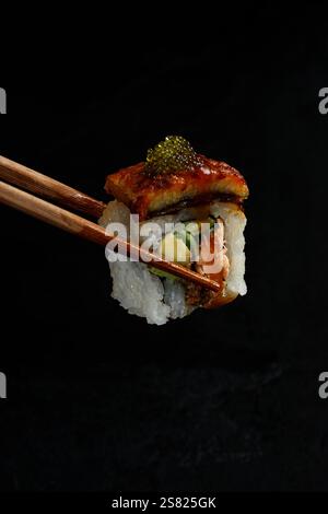 Sushi Rolls mit Stäbchen in der Hand essen, Sushi Roll nehmen, Susi essen im japanischen Restaurant Closeup Stockfoto
