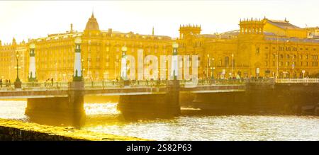 Kursaalbrücke bei Sonnenuntergang mit Victoria Eugenia Theater und Maria Cristina Hotel. San Sebastian, Spanien Stockfoto