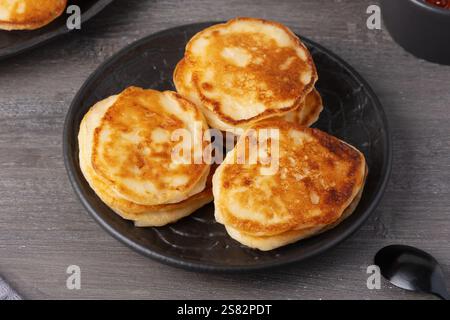 Köstlicher Stapel goldener Pfannkuchen, serviert mit Kaviar auf einem rustikalen Tisch Stockfoto