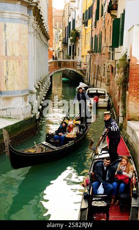 VENEDIG, ITALIEN - 14. FEBRUAR 2015: Viel Gondelverkehr an engen Kanälen am Valentinstag während des Karnevals. Stockfoto