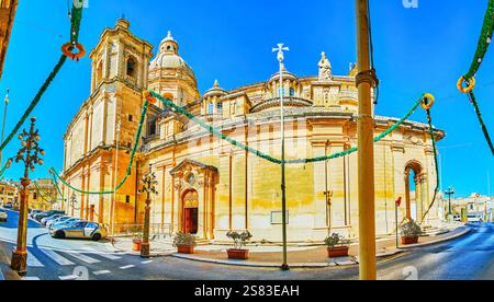 Panorama der Pfarrkirche St. Nikolaus mit kunstvollen Steinschnitzereien, einem hohen Glockenturm und einer riesigen Kuppel, umgeben von farbenfrohen festlichen Dekorationen, Sigg Stockfoto