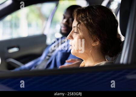 Ehemann und Ehefrau machen eine Probefahrt, um vor dem Kauf Warnschilder zu erkennen, um sicherzustellen, dass er sich wohl fühlt. Mann und Frau inspizieren das Fahrzeuginnere, bevor sie das Grundstück verlassen Stockfoto