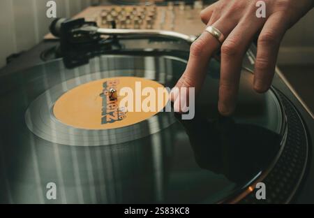 DJ mit Hand auf einer Schallplatte Stockfoto