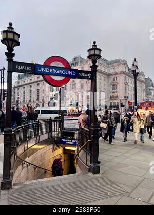Geschäftiger Piccadilly Circus mit Leuten, die laufen. Nahaufnahme der Treppe und des Eingangs zur Londoner U-Bahn. Während des Tages eingenommen. Stockfoto
