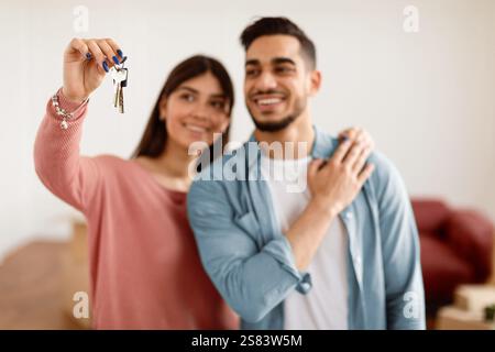 Glückliches Paar zeigt Schlüssel ihrer Wohnung, selektiver Fokus Stockfoto