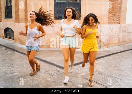 Drei glückliche Freunde laufen in der Stadt Stockfoto