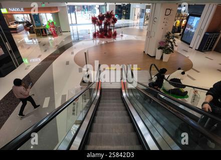 Century Place, Shenzhen, China - 20. Januar 2025 : Ein größtenteils leeres Einkaufszentrum mit Rolltreppen, polierten Böden und minimalen Einkäufern Stockfoto