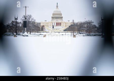 Washington, D.C. USA - 6. Januar 2025: Blick auf das Capitol-Gebäude im Schnee durch schwarze Zäune vor Präsident Carters Liegenschaft. Stockfoto