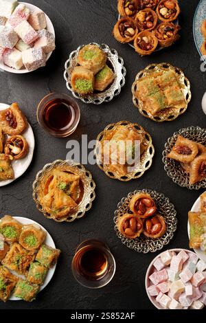 Köstliche Auswahl an Nahost-Süßigkeiten, serviert mit Tee auf eleganten Tellern Stockfoto