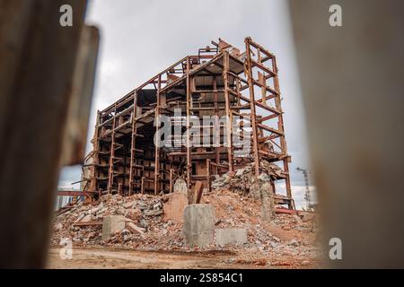 Rostige Metallbalken und Schutthaufen markieren den Standort eines abgerissenen Gebäudes in russland, was den urbanen Niedergang und den industriellen Niedergang unterstreicht Stockfoto