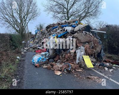 Der zehn Meter hohe Abfallhaufen aus der Water Lane am Stadtrand von Lichfield in Staffordshire. Die Kommunalbehörde sucht nach Videonachweisen, um die Fliegenkipper aufzuspüren, die einen riesigen Hügel mit Baumüll über 40 Meter entlang einer zweispurigen Straße ablegten und den Zugang zu Häusern und Unternehmen blockierten. Bilddatum: Dienstag, 21. Januar 2025. Stockfoto