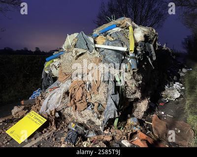 Der zehn Meter hohe Abfallhaufen aus der Water Lane am Stadtrand von Lichfield in Staffordshire. Die Kommunalbehörde sucht nach Videonachweisen, um die Fliegenkipper aufzuspüren, die einen riesigen Hügel mit Baumüll über 40 Meter entlang einer zweispurigen Straße ablegten und den Zugang zu Häusern und Unternehmen blockierten. Bilddatum: Dienstag, 21. Januar 2025. Stockfoto
