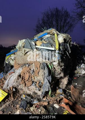 Der zehn Meter hohe Abfallhaufen aus der Water Lane am Stadtrand von Lichfield in Staffordshire. Die Kommunalbehörde sucht nach Videonachweisen, um die Fliegenkipper aufzuspüren, die einen riesigen Hügel mit Baumüll über 40 Meter entlang einer zweispurigen Straße ablegten und den Zugang zu Häusern und Unternehmen blockierten. Bilddatum: Dienstag, 21. Januar 2025. Stockfoto
