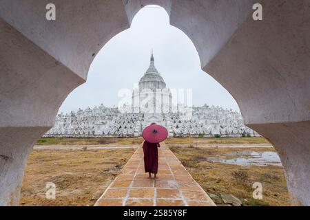 Ein junger asiatischer Mönch steht an der Mya Thein Tan Pagode in Mingun, Mandalay, Myanmar (Birma) Stockfoto