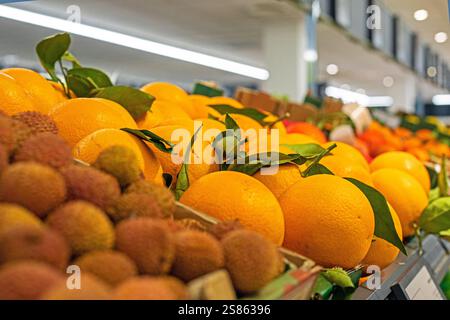 Lycho-Früchte, Orangen, Mandarinen, in einem Supermarkt in einem Container Stockfoto