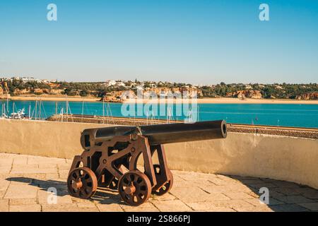 Küstenkanone mit malerischem Blick auf den Yachthafen und die Klippen. Stockfoto