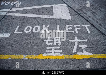 Links schauen, Warnhinweis auf dem Asphalt, Hongkong, Volksrepublik China *** links schauen, Warnschild auf dem Asphalt, Hongkong, Volksrepublik China Stockfoto