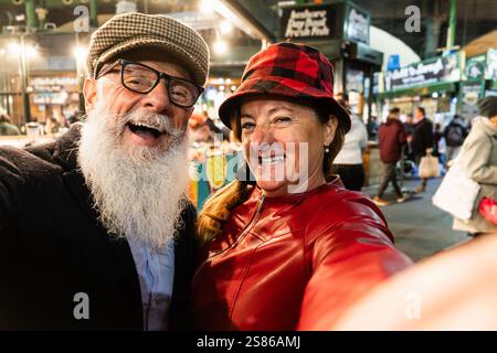 Glückliches Seniorenpaar, das Spaß hat, zusammen ein Selfie auf dem Lebensmittelmarkt zu machen - Modefrau und Mann machen eine Stadtbesichtigung in London - Travel and Joyful el Stockfoto