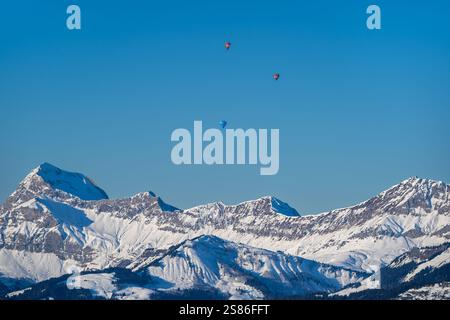 Drei Ballons, die gegen einen blauen Himmel über den Gipfeln der französischen Alpen schweben Stockfoto