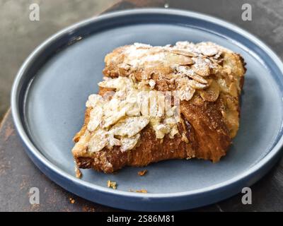 Ein Teller Croissants mit Puderzucker und Mandelflocken Stockfoto
