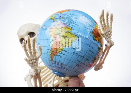 Die Erde in einer Skeletthand Stockfoto