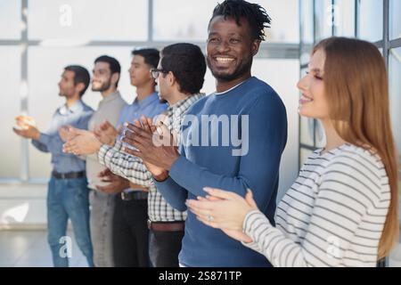 Vielfältige Gruppe von Geschäftsleuten, die bei einer Konferenz lächeln und klatschen, mit Standing Ovation Stockfoto