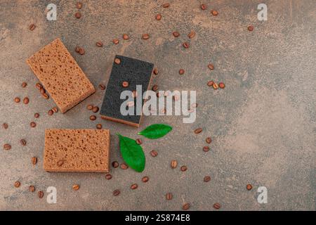 Set mit Schwämmen zum Waschen von Geschirr. Organisches Reinigungskonzept, Kaffeearoma. Null-Abfall-Stil, warmer brauner Steinhintergrund, flache Lage, Draufsicht Stockfoto