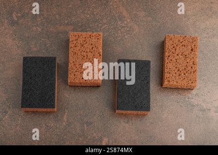 Set mit Schwämmen zum Waschen von Geschirr. Organisches Reinigungskonzept, Kaffeearoma. Null-Abfall-Stil, warmer brauner Steinhintergrund, flache Lage, Draufsicht Stockfoto