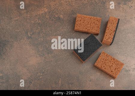 Set mit Schwämmen zum Waschen von Geschirr. Organisches Reinigungskonzept, Kaffeearoma. Null-Abfall-Stil, warmer brauner Steinhintergrund, flache Lage, Draufsicht Stockfoto
