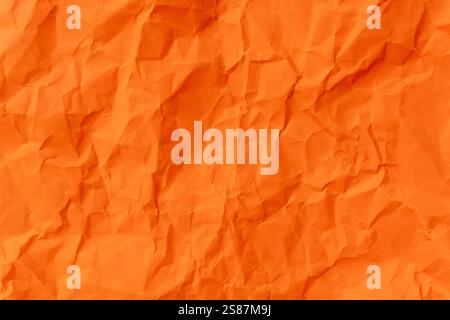 Die Draufsicht und der ganze Rahmen von zerknittertem oder zerknittertem orangefarbenem Papier werden als Hintergrund für zerknittertes orangefarbenes Papier verwendet. Stockfoto