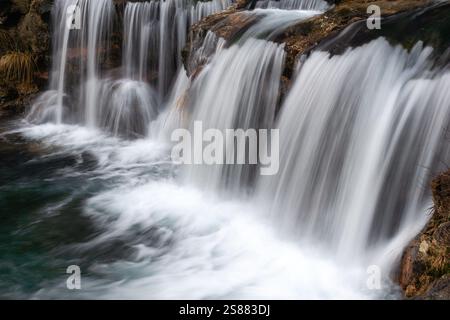 Faszinierender Wasserfall, der sich über felsiges Gelände zieht, mit seidenglatten Wasserläufen, die eine ruhige und ruhige Naturszene schaffen, perfekt für die Landschaft Stockfoto