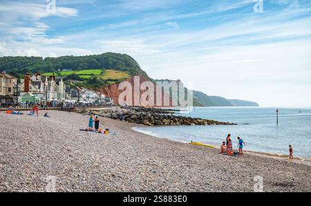 Blick nach Osten auf den Strand von Sidmouth mit den roten Klippen entlang der Küste. Sidmouth, Devon, England, Großbritannien. Stockfoto