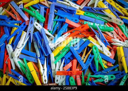 Ein Haufen bunter Wäscheklammern aus Plastik, mit denen gewaschene Kleidung an eine Wäscheleine gehängt wird Stockfoto