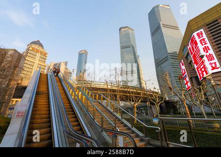 Shanghai, China. Januar 2025. Rolltreppen, die zu einem Fußgängerübergang über einer großen Straßenkreuzung aufsteigen Stockfoto