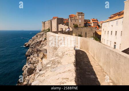 Blick nach Westen entlang der südlichen Stadtmauer, die entlang hoher, defensiver Felsklippen gebaut wurde, und Blick auf das Meer vom südlichen Aspekt der ummauerten Altstadt von Dubrovnik aus, historische Stadtmauern. Kroatien. (138) Stockfoto