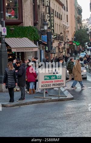 Madrid, Spanien - 21. Januar 2025: Stadtstraße in Madrid mit Restaurant El Principe, Polizeischild in Puerta del Sol und mehreren Fußgängern und Geschäften, Stockfoto