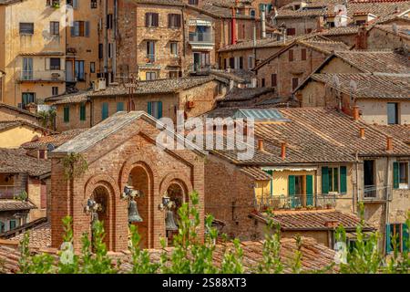 Der Glockenturm des Heiligtums des Hauses der Heiligen Katharina und Gebäude der mittelalterlichen Stadt Siena in der Toskana, Italien Stockfoto
